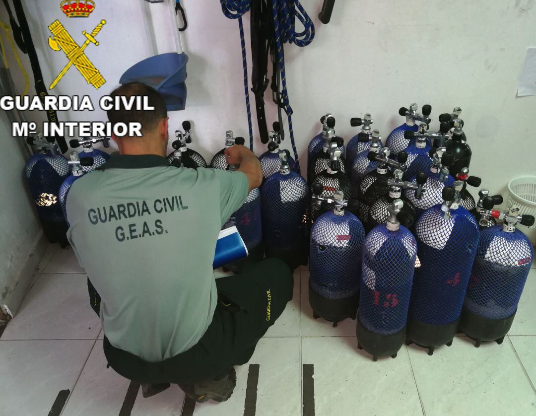 Uno de los agentes del GEAS inspecciona botellas de aire.