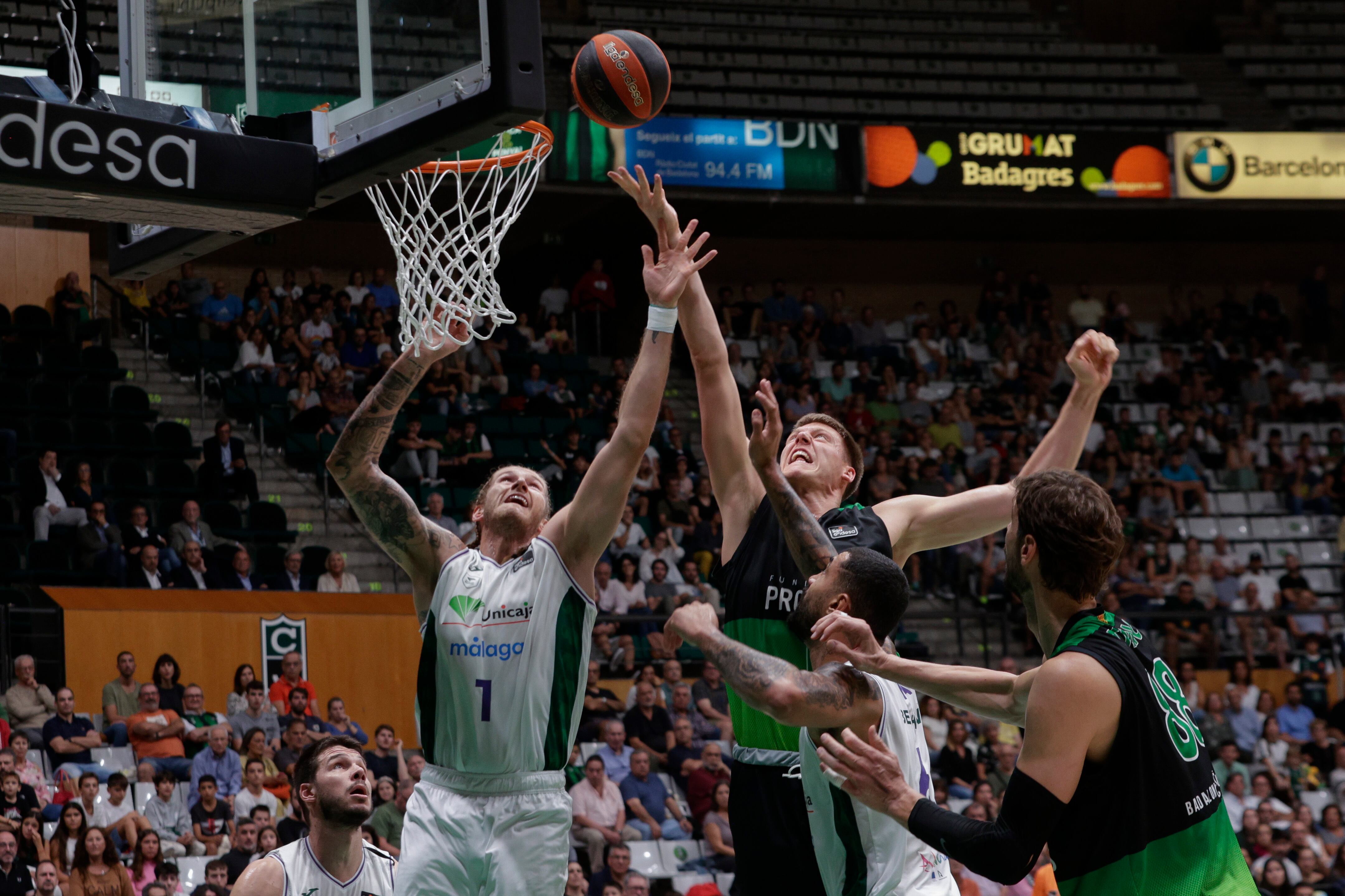 BARCELONA , 23/10/2022.- El pivot estadounidense de Unicaja, Osetkowski (i), pelea un rebote en el jugador sueco del Joventut, Simon Birgander, durante el partido de la jornada 5 de la Liga Endesa disputado, esta tarde, en el Pabellón Olímpico de Badalona entre el Joventut y el Unicaja. EFE/ Quique García