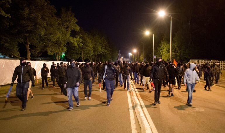 Los sujetos que protagonizaron los disturbios contra la policía, portando palos y banderas. 