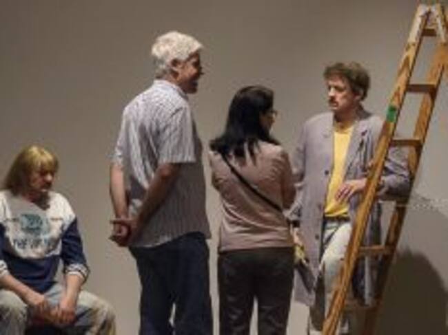 Dos visitantes (en el centro de pie) observan la obra "Two Workers" de Duane Hanson, perteneciente a la exposición "Escultura Hiperrealista 1973-2016"