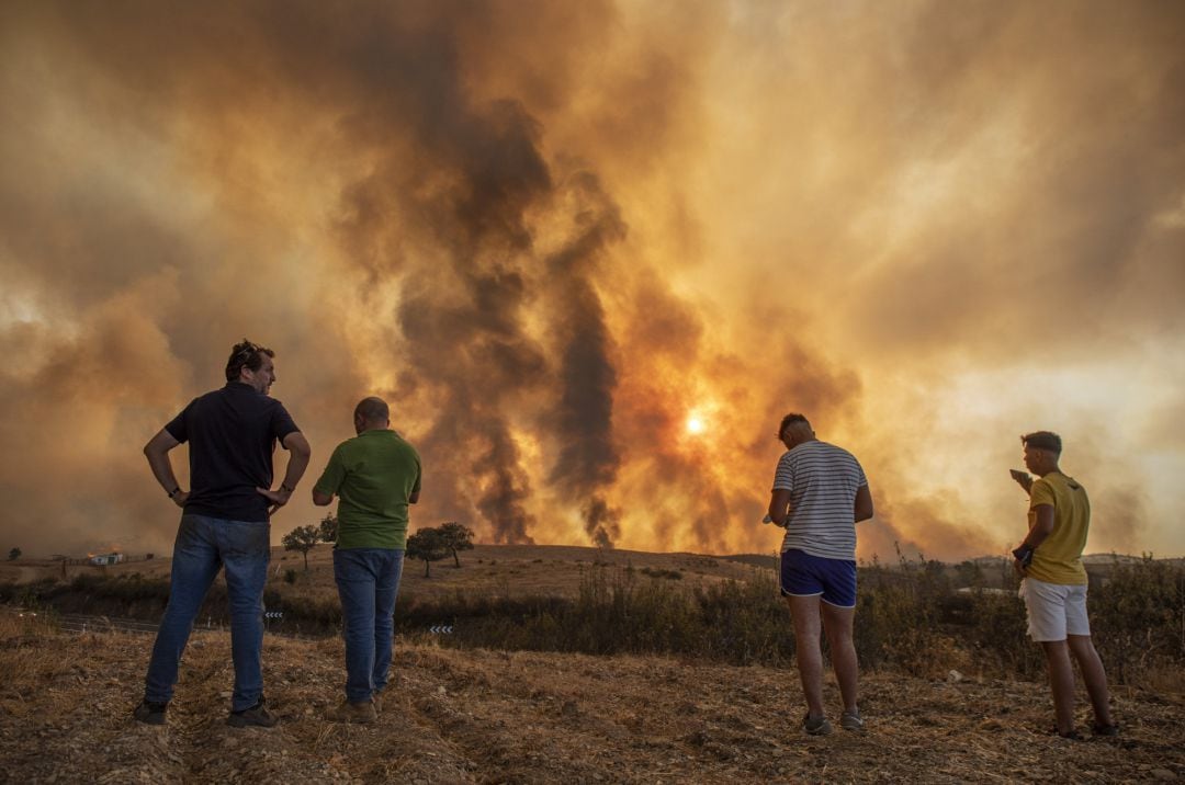 Vecinos observan el incendio forestal declarado en el Paraje Olivargas de Almonaster la Real (Huelva, Andalucía, España)