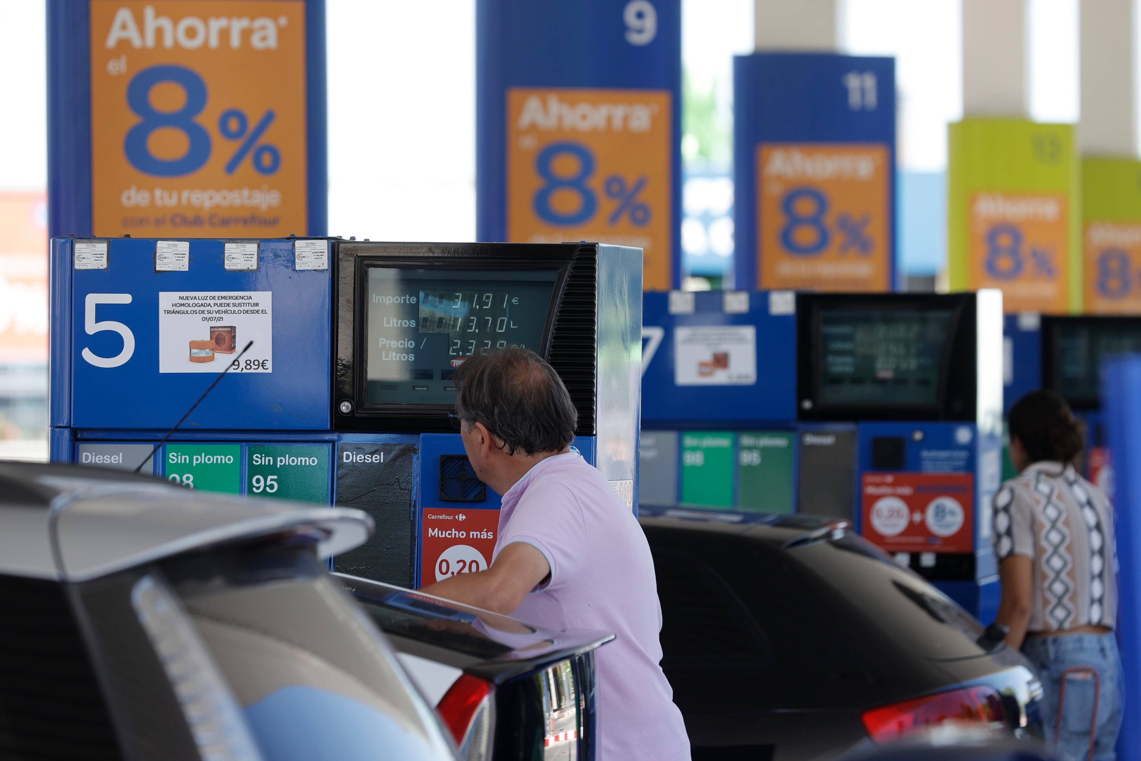 Dos personas repostan en una gasolinera de Madrid.