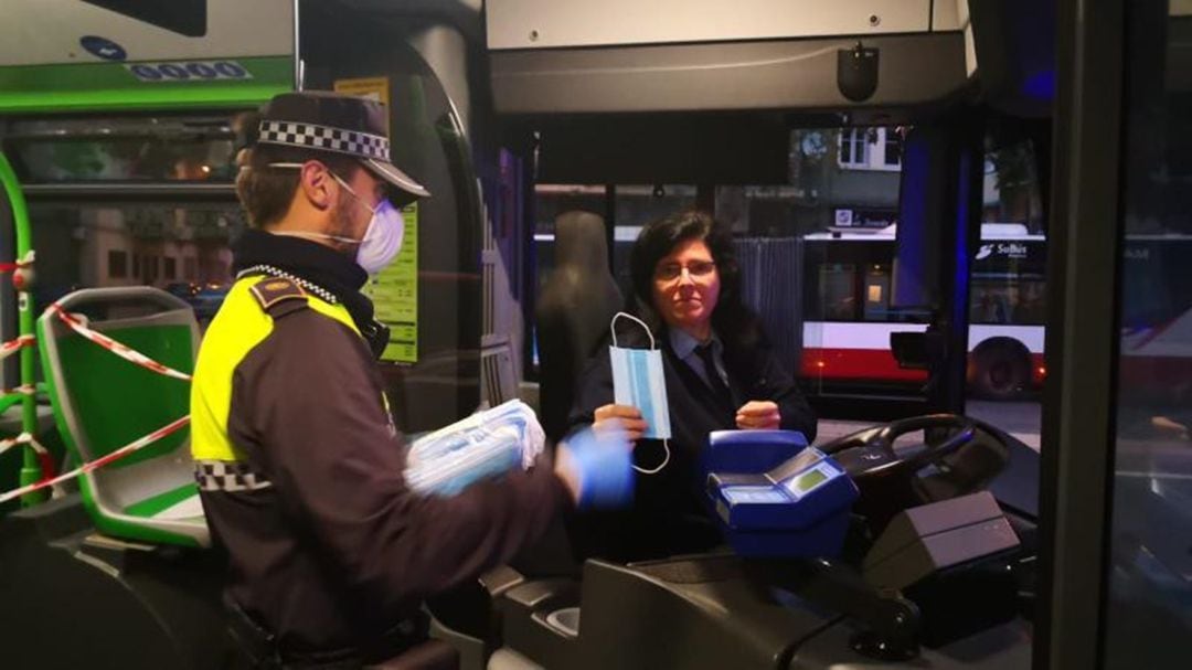 Un policía local repartiendo mascarillas