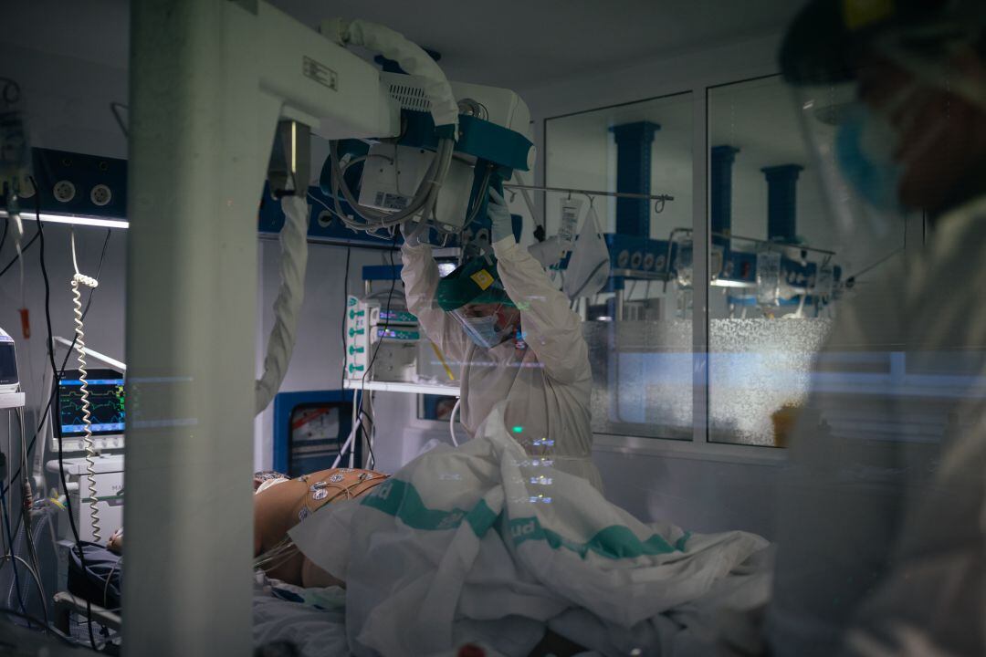 Personal sanitario observa a un paciente de COVID-19 en la UCI. 