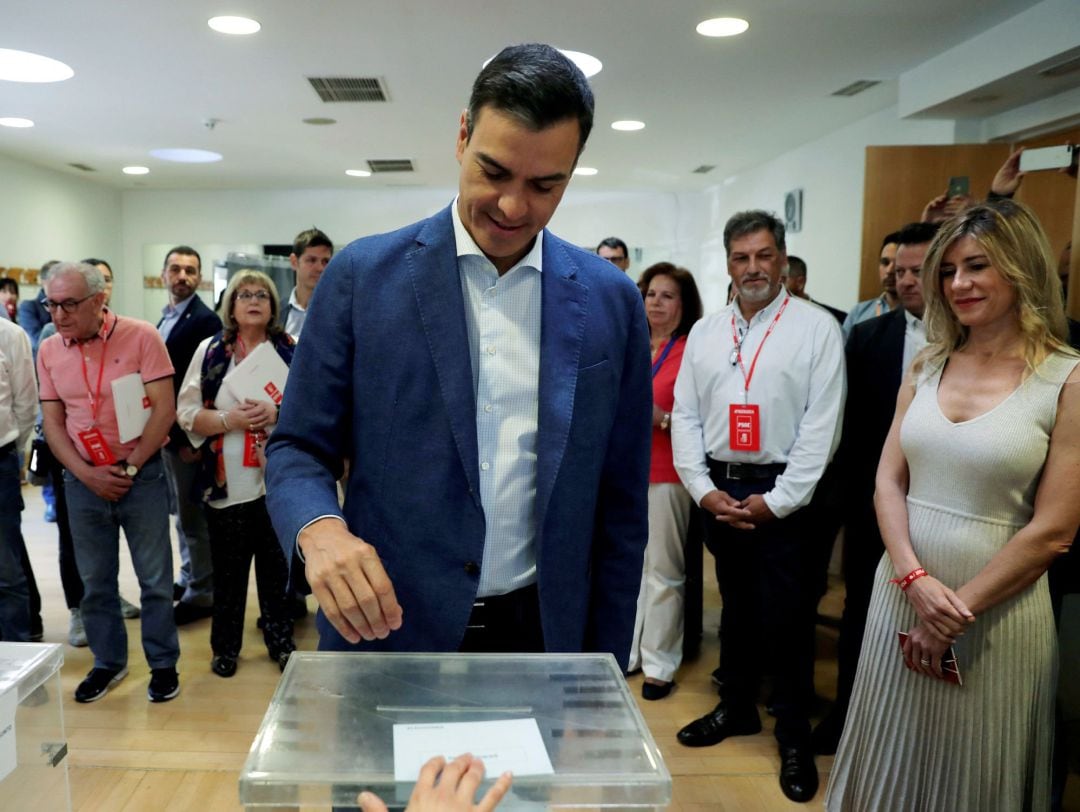 El presidente del gobierno Pedro Sánchez, acompañado de su mujer Begoña Gómez (d), vota esta mañana en un colegio de la localidad madrileña de Pozuelo de Alarcón.