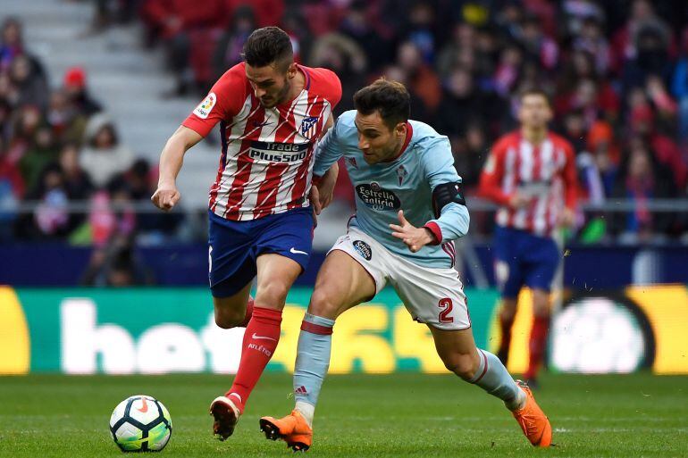 Hugo Mallo persigue un balón, ante Koke, en un partido de la pasada temporada