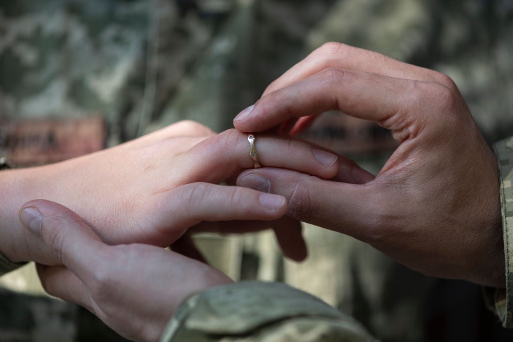 Una persona le pone un anillo en el dedo a otra
