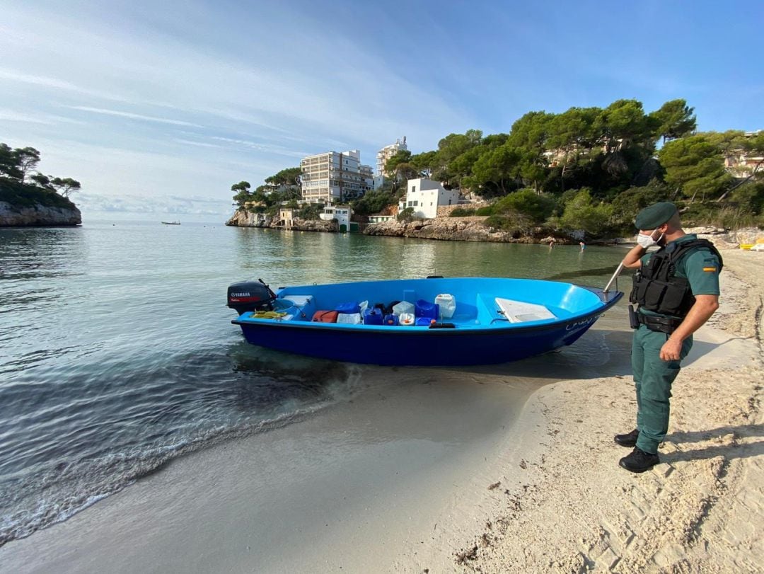 Un agente de la guardia civil, junto a una embarcación, en una playa en una imagen de archivo