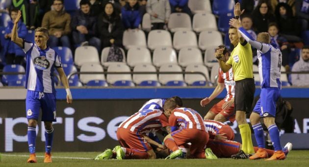 Los jugadores del Atlético tratan de socorrer a Torres mientras el árbitro y los del Deportivo piden ayuda a los médicos