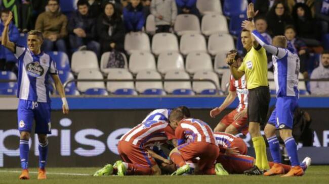 Los jugadores del Atlético tratan de socorrer a Torres mientras el árbitro y los del Deportivo piden ayuda a los médicos