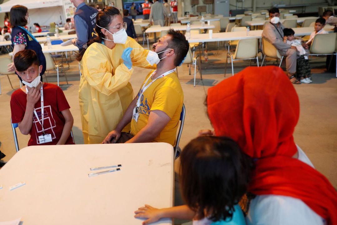 Personal sanitario somete a una prueba PCR a los llegados a la base aérea militar de Torrejón de Ardoz