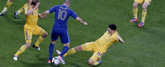 El francés Karim Benzema se disputa el control del balón con los ucranianos durante el partido de la primera fase de la Eurocopa 2012