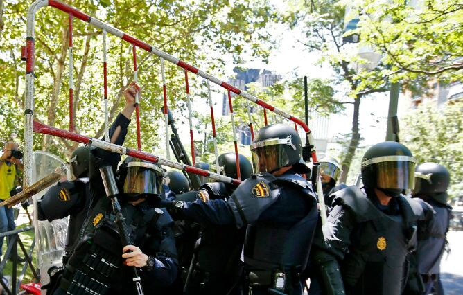 Agentes antidisturbios detienen una valla lanzada por participantes en la manifestación que se desarrolló hoy en Madrid en apoyo de la minería del carbón