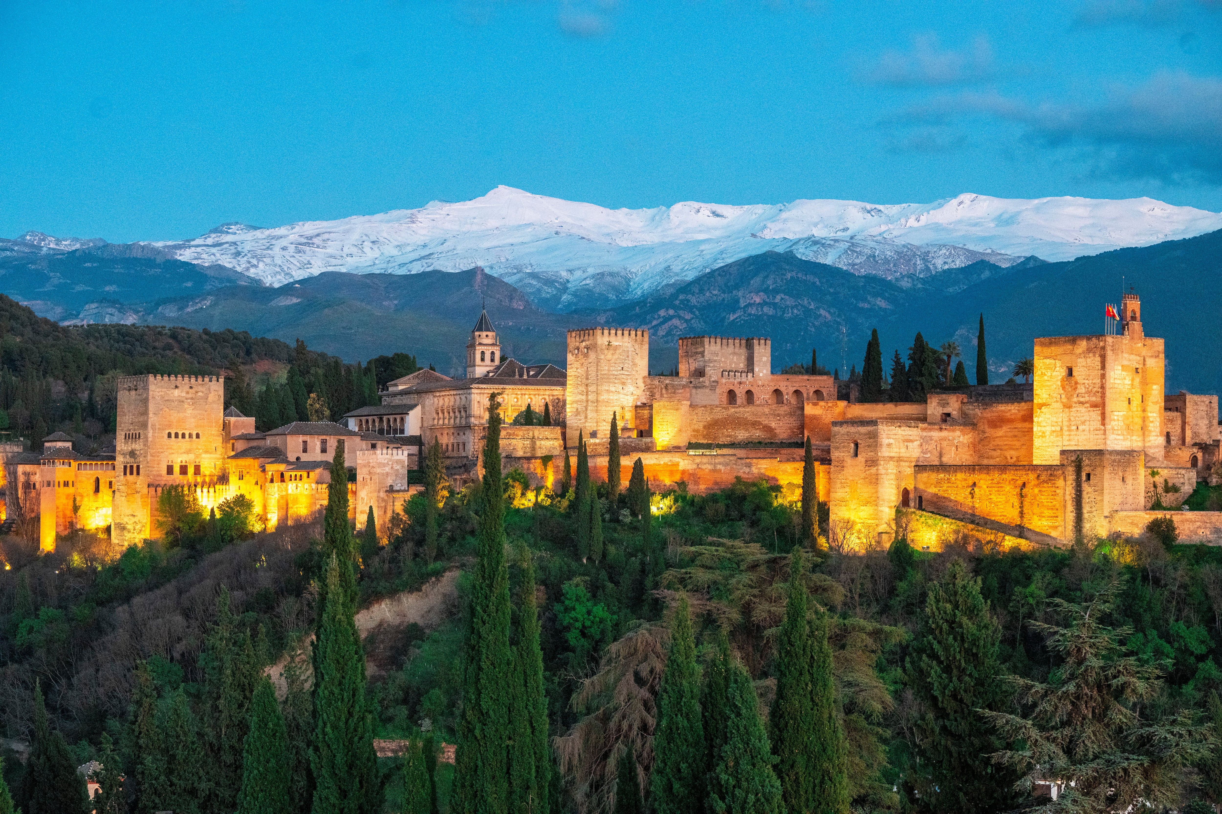 La Alhambra de Granada, con Sierra Nevada al fondo, en una imagen de una puesta de sol del 3 de abril de 2024 que puede contemplarse desde la Iglesia de Santa María de la Aurora y San Miguel en pleno barrio morisco del Albaicín