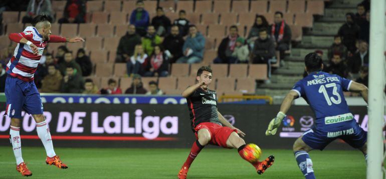 El defensa del Athletic Aymeric Laporte (c) intenta batir al portero del Granada Andrés Fernández (d) durante el partido de la duodécima jornada de liga en Primera División que se disputa esta noche en el estadio Nuevo Los Cármenes