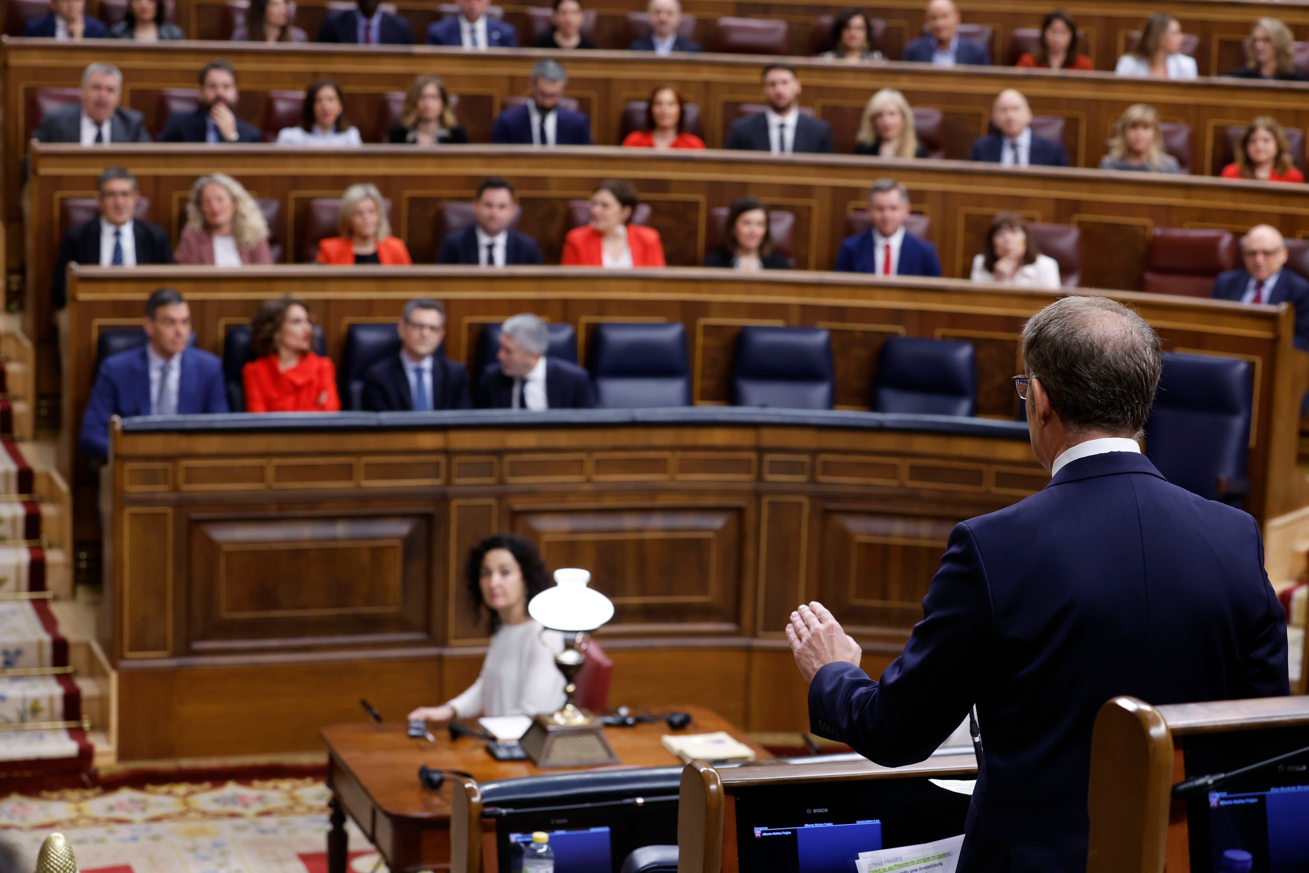 El líder del PP, Alberto Núñez Feijóo (d, de espaldas), se dirige al presidente del Ejecutivo, Pedro Sánchez durante una sesión de control al Gobierno. Archivo.