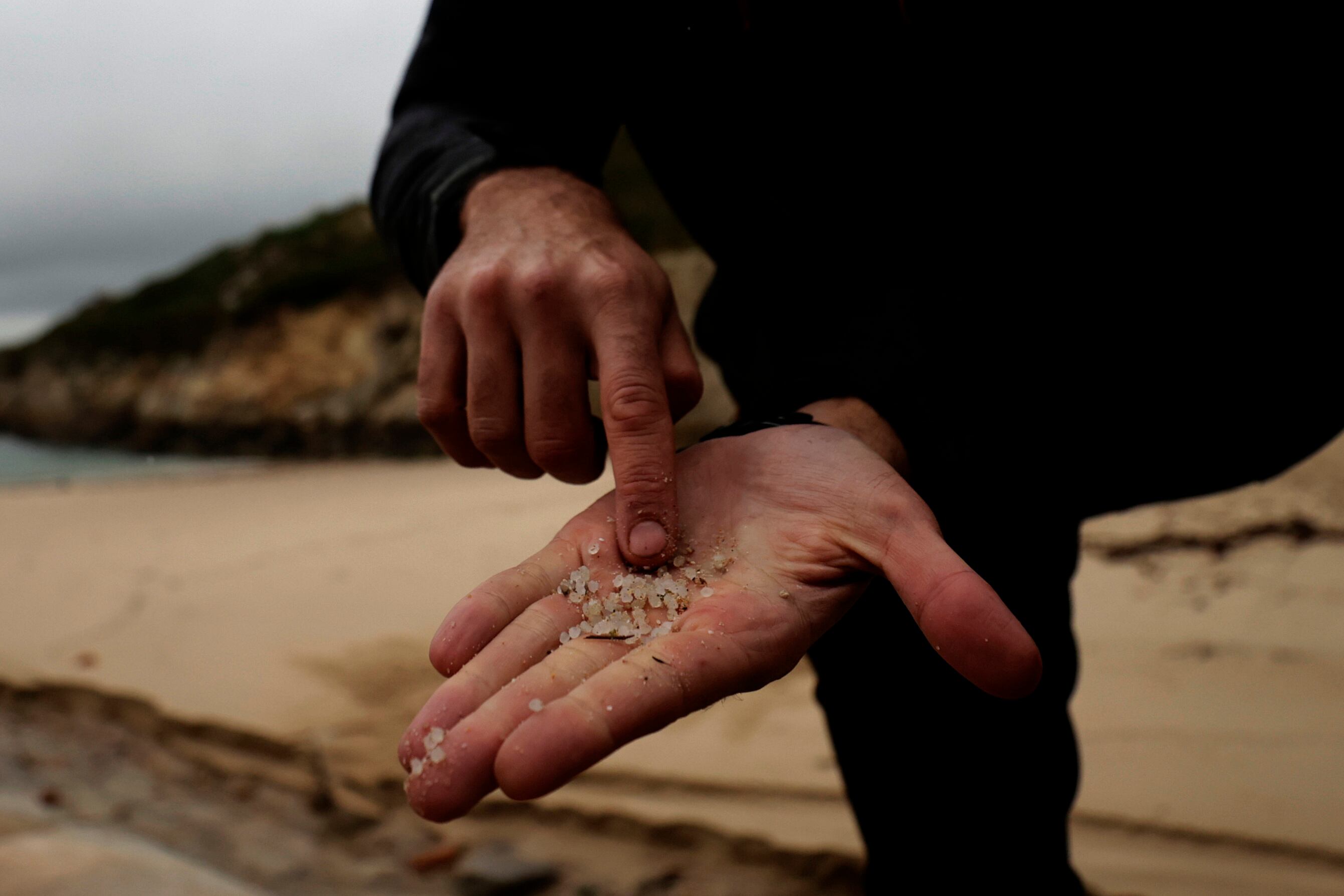 Una persona muestra pellets recogidos en la playa de As Lapas, en A Coruña. EFE/Cabalar