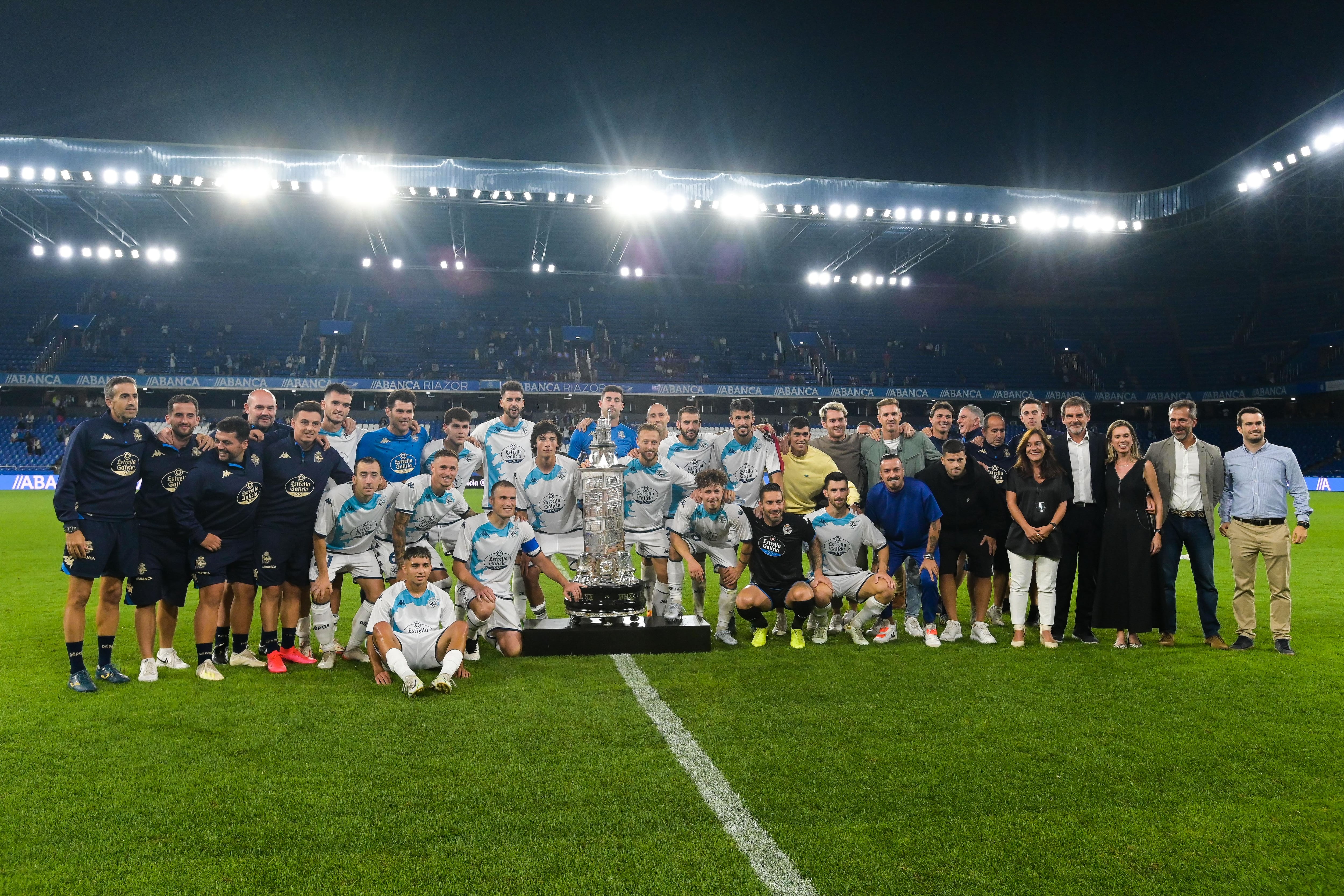 LA CORUÑA, 13/08/2022.- Jugadores y cuerpo técnico del Deportivo posan con el Trofeo Teresa Herrera tras vencer al Metalist Járkov este sábado en el estadio Abanca Riazor de A Coruña. EFE/ Moncho Fuentes