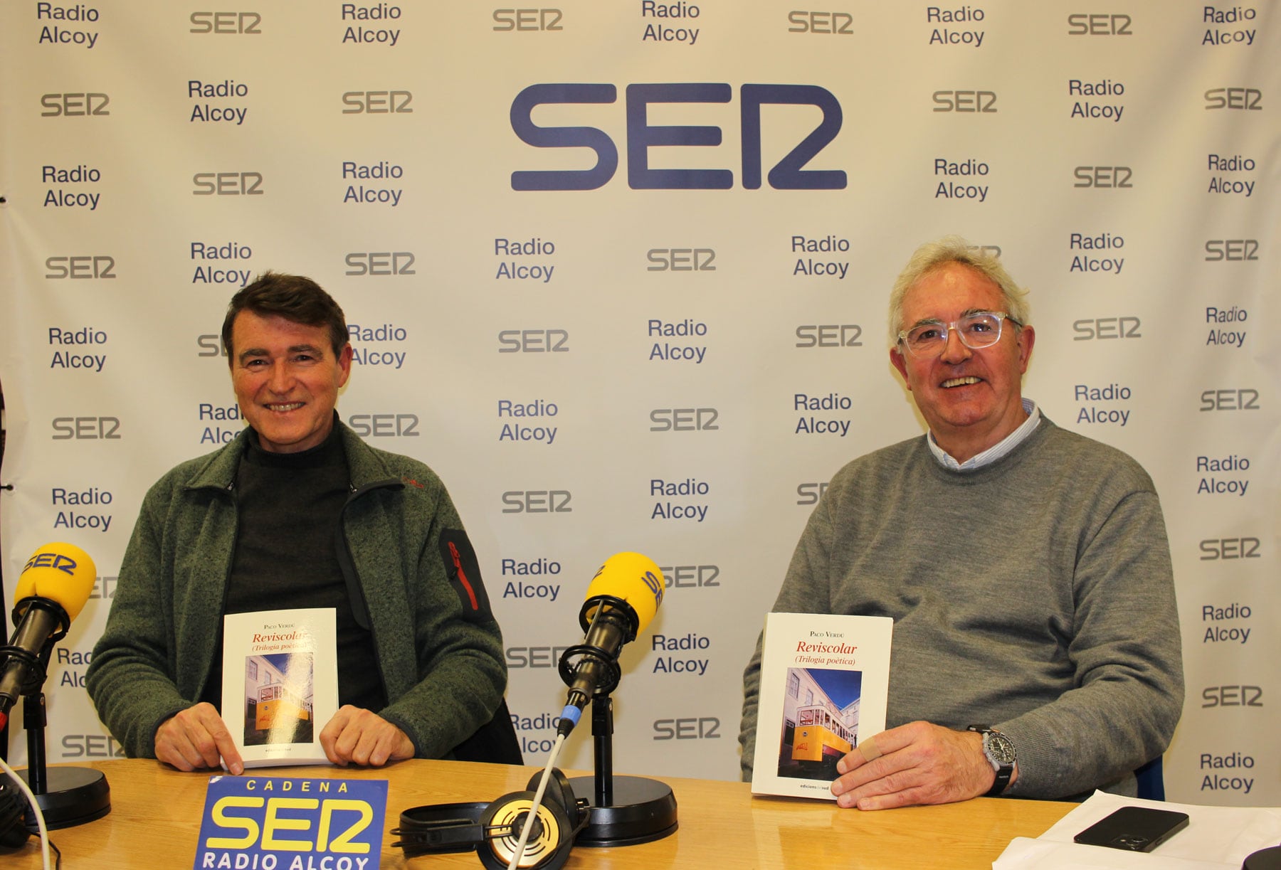 Jordi Raül Verdú i Paco Verdú, en l&#039;estudi central de Radio Alcoy, amb un exemplar del llibre &#039;Reviscolar (Trilogia poètica)&#039;