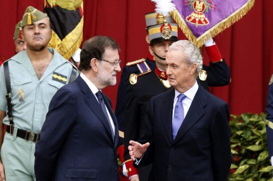 El presidente del Gobierno, Mariano Rajoy (i), conversa con el ministro de Defensa, Pedro Morenés (d), al término del desfile del Día de la Fiesta Nacional.