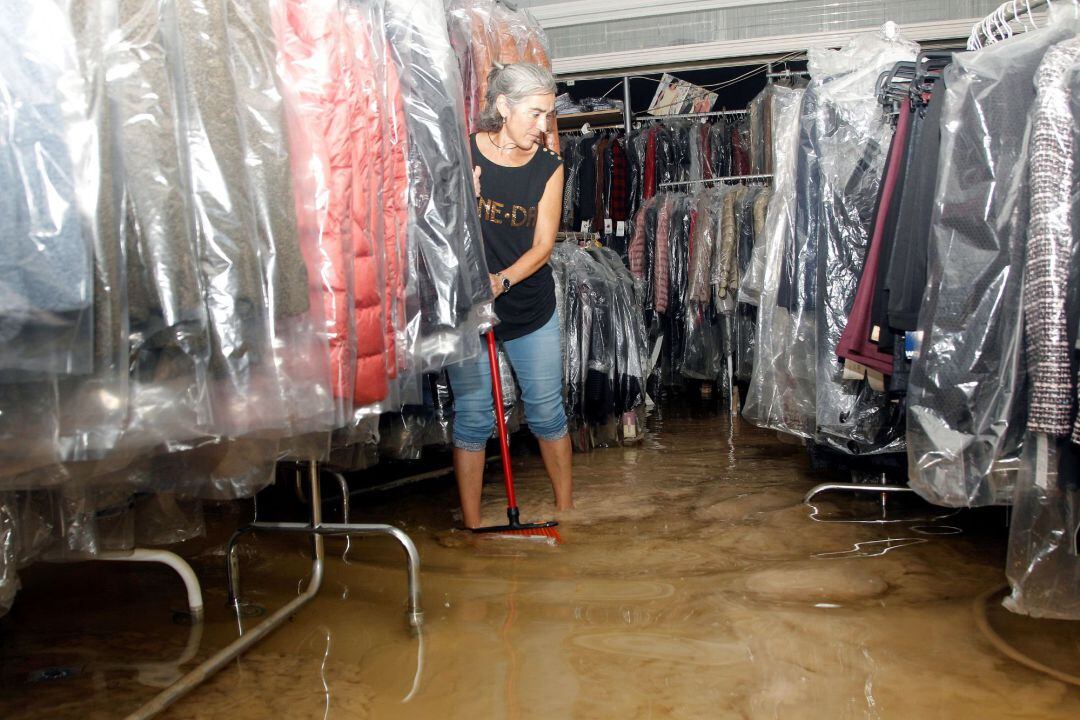 Vecinos de Orihuela limpian sus casas y negocios anegados por la avenida de agua povocada por el desbordamiento del río Segura tras el paso de la Gota Fría en la Comunidad Valenciana