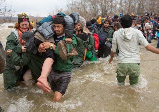 Migrantes cruzando un río para intentar llegar a Macedonia