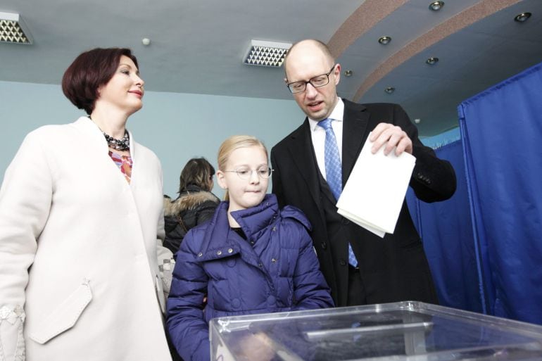 Ukraine&#039;s Prime Minister Arseny Yatseniuk (R) casts his ballot, as his daughter Sofiya (C) and wife Teresiya stand nearby, during a parliamentary election at a polling station in Kiev, October 26, 2014. Ukrainians voted on Sunday in an election that is li