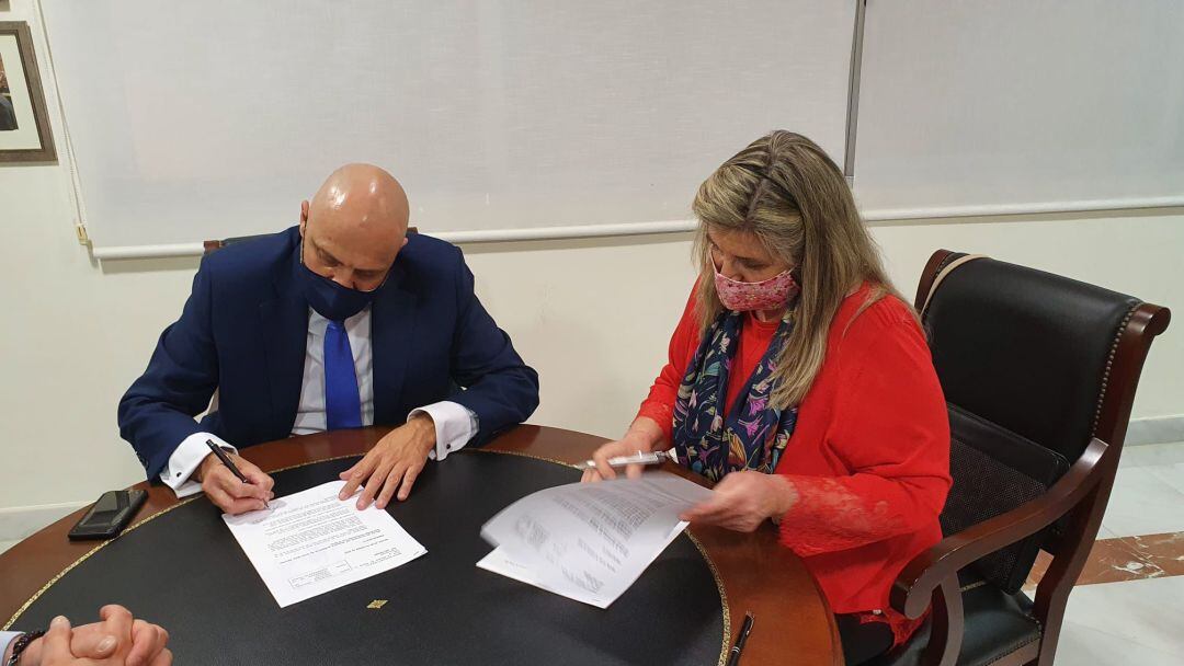 El hermano mayor de la Esperanza de Triana, Sergio Sopeña, y lka economista Maite Sánchez, durante la firma del acuerdo