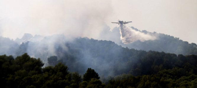 Una avioneta trabaja en la extinción del incendio que desde este viernes está calcinando cientos de hectáreas de los montes adyacentes a los municipios de Andratx y Estellens en Mallorca