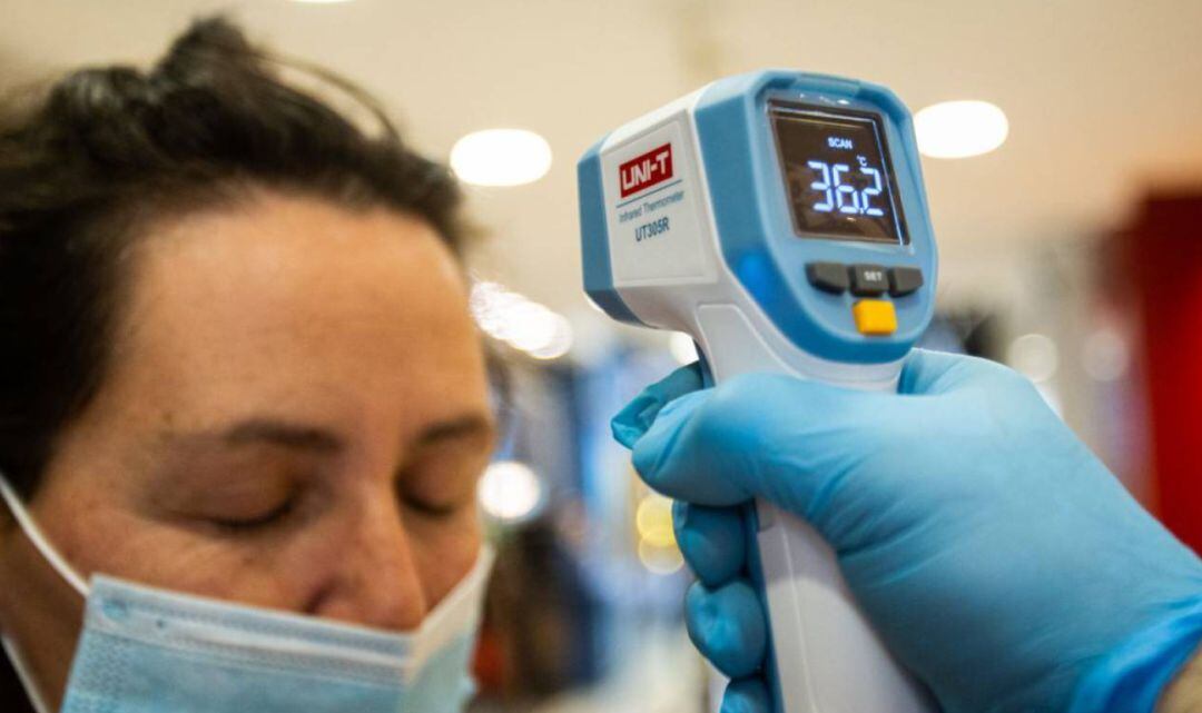 A una mujer le toman la temperatura.