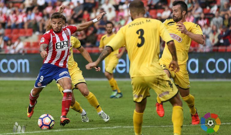 Portu, autor del gol de la victòria gironina, en una acció davant la defensa del Reus.