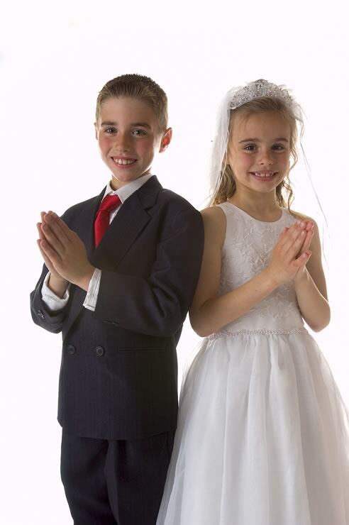 Dos niños posan con sus vestidos en el día de su Primera Comunión