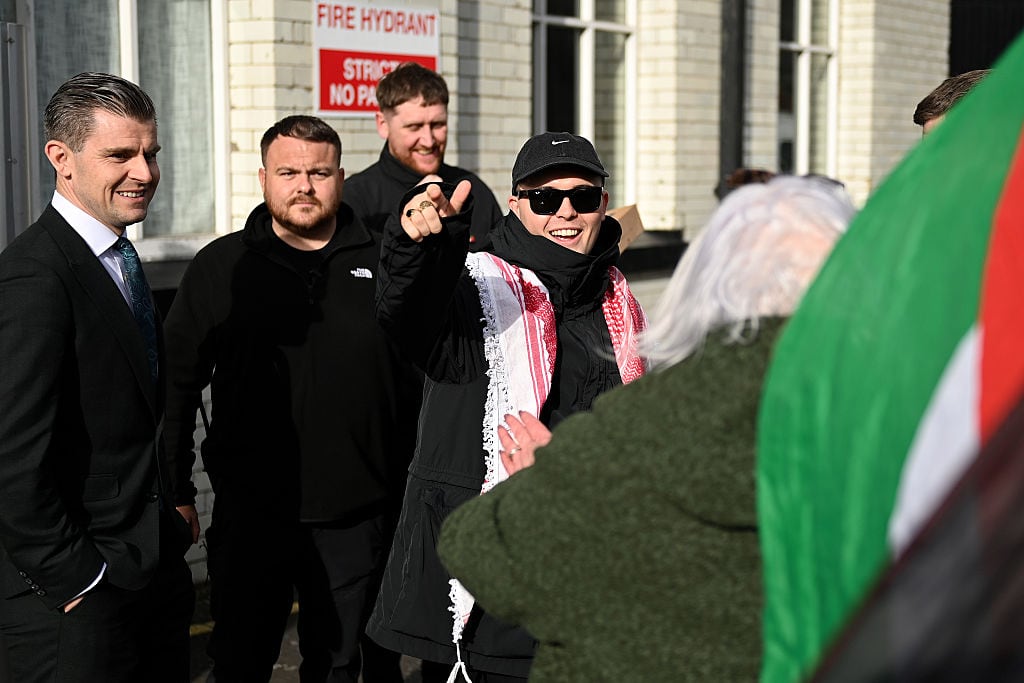 Liam Óg Ó hAnnaidh (C), de la banda Kneecap, saluda a los simpatizantes junto a su abogado Darragh Mackin (I)