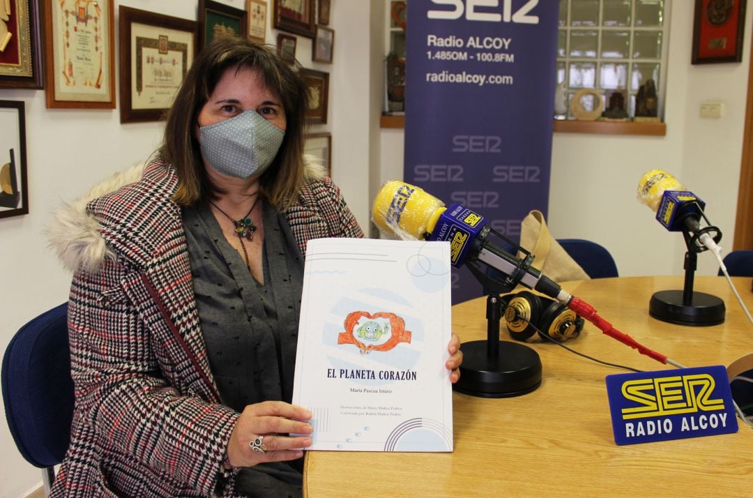 Marta Pascua en el estudio de Radio Alcoy muestra un ejemplar de su cuento