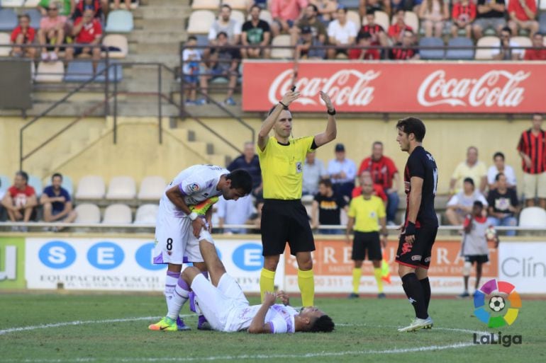 El numantino Callens, en el suelo, es atendido en la recta final del partido ante el Reus. 