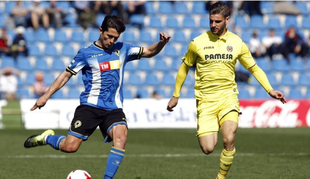 Juanjo Nieto pone un centro ante la presión de un jugador del Villarreal B.