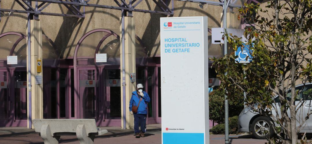 Un hombre pasea al lado de uno de los carteles indicativos del Hospital Universitario de Getafe