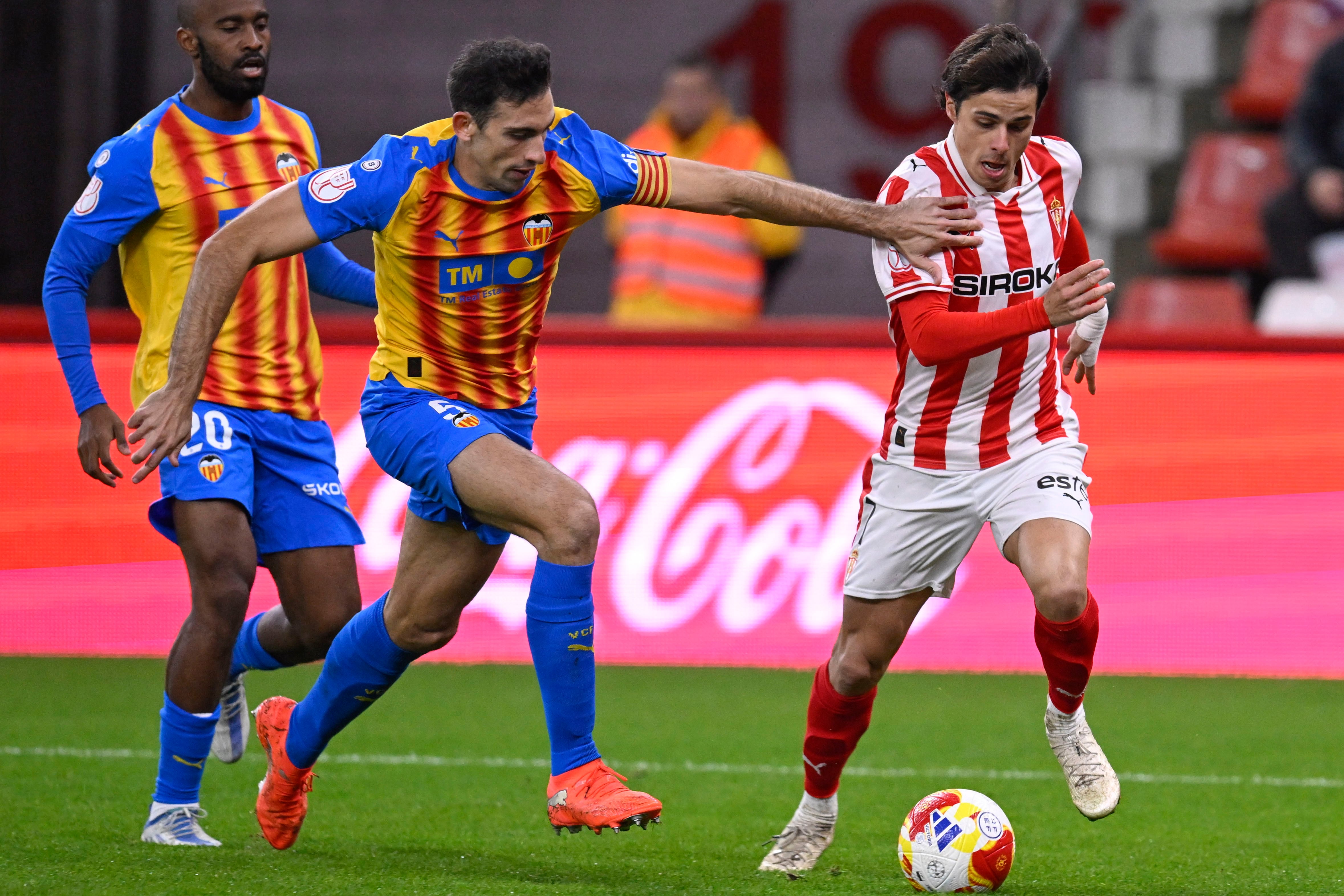 GIJÓN, 16/12/2025.- El defensa del Valencia César Tárrega (i) persigue a Gaspar Campos, del Sporting, durante el partido de dieciseisavos de final de la Copa del Rey que Sporting de Gijón y Valencia CF disputan este martes en el estadio de El Molinón, en Gijón. EFE/Eloy Alonso