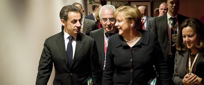 El presidente francés Nicolás Sarkozy y la canciller alemana Ángela Merkel, charlan mientras se dirigen a la cena de trabajo en Bruselas