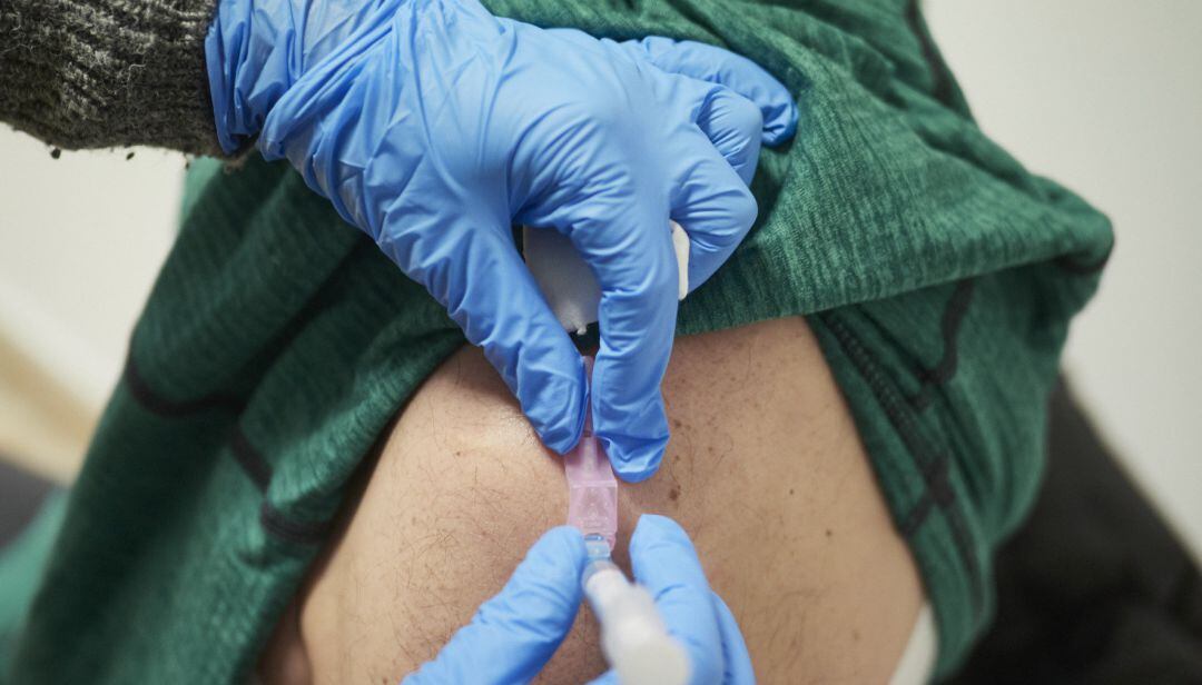 Una sanitaria vacuna contra el Covid-19 a una persona.