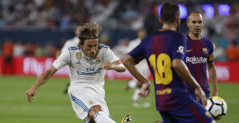 Luka Modric dispara a puerta ante Iniesta y Jordi Alba