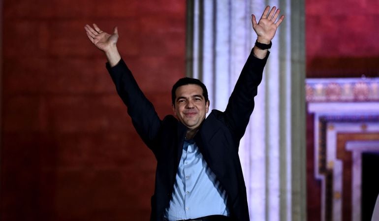 Syriza leader Alexis Tsipras raises his fist as he greets supporters following victory in the election in Athens on January 25, 2015. The left-wing Syriza party led by Alexis Tsipras won Greece&#039;s general election  after campaigning on a pledge to renegoti