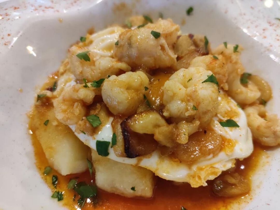 Colas de cigala al ajillo con huevos rotos y patatas pochadas