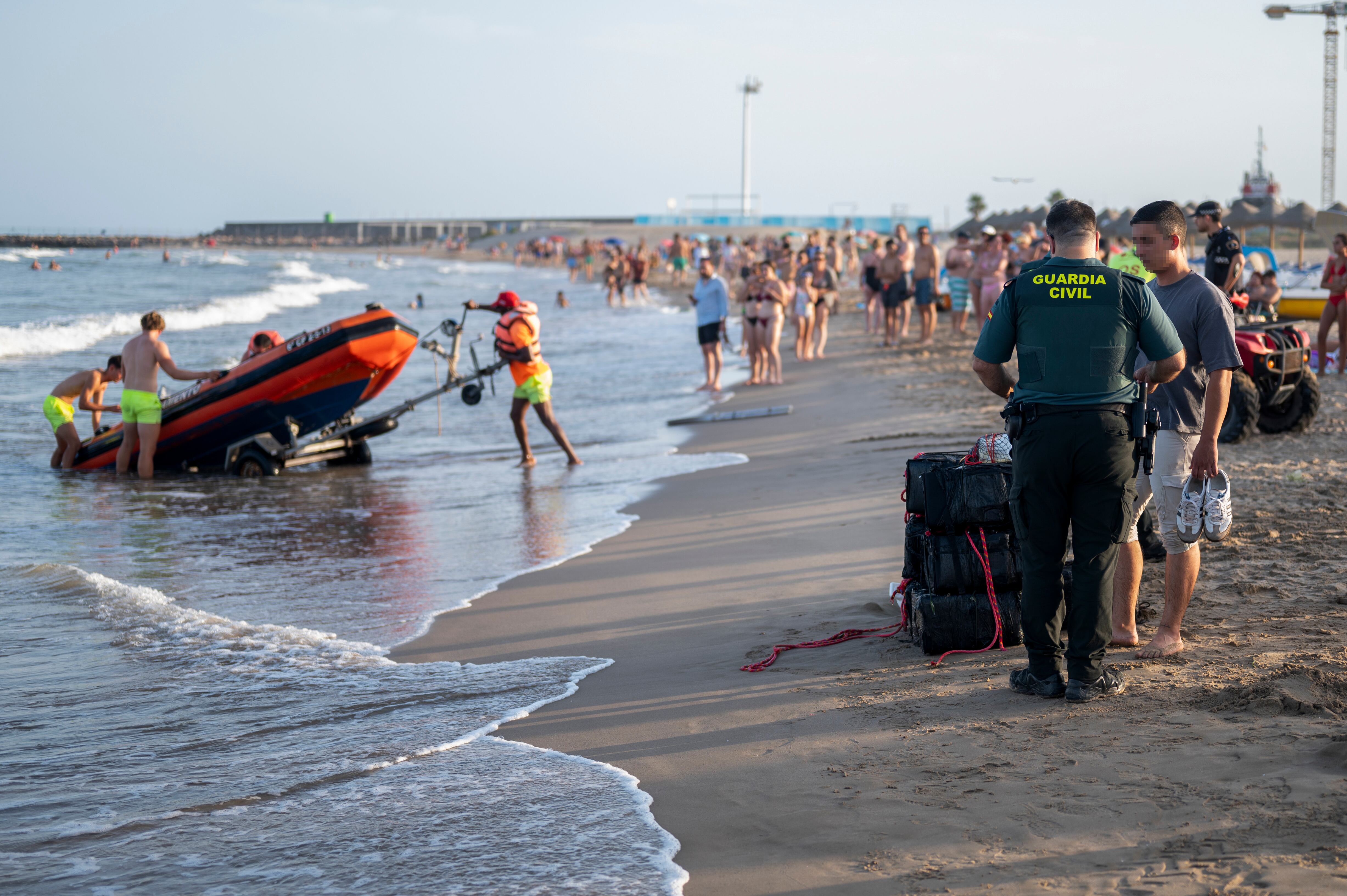 GRAFCVA1926. BURRIANA (CASTELLÓN), 17/07/2024.- Agentes de la Guardia Civil han retirado de la playa del Arenal de Burriana más de una decena de fardos negros que han sido acercados a la orilla por efectivos de Salvamento Marítimo tras haber sido hallados enganchados a una boya. EFE/Andreu Esteban
