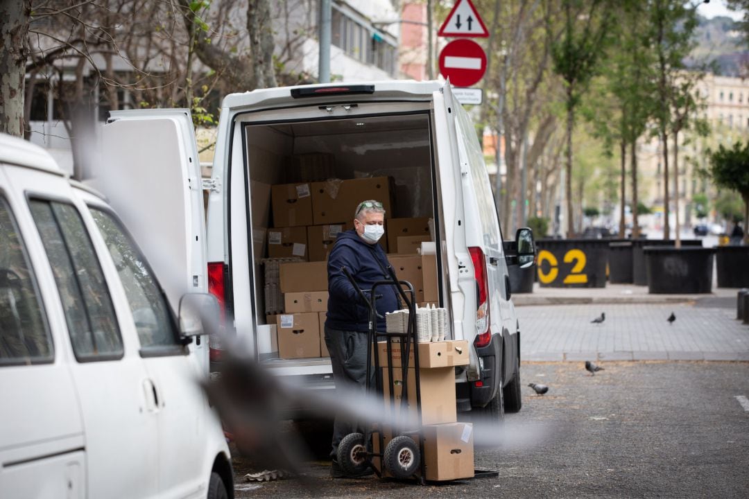 Un hombre protegido con mascarilla trabaja de repartidor durante el noveno día laborable desde que se decretó el estado de alarma en el país a consecuencia del coronavirus, en Barcelona