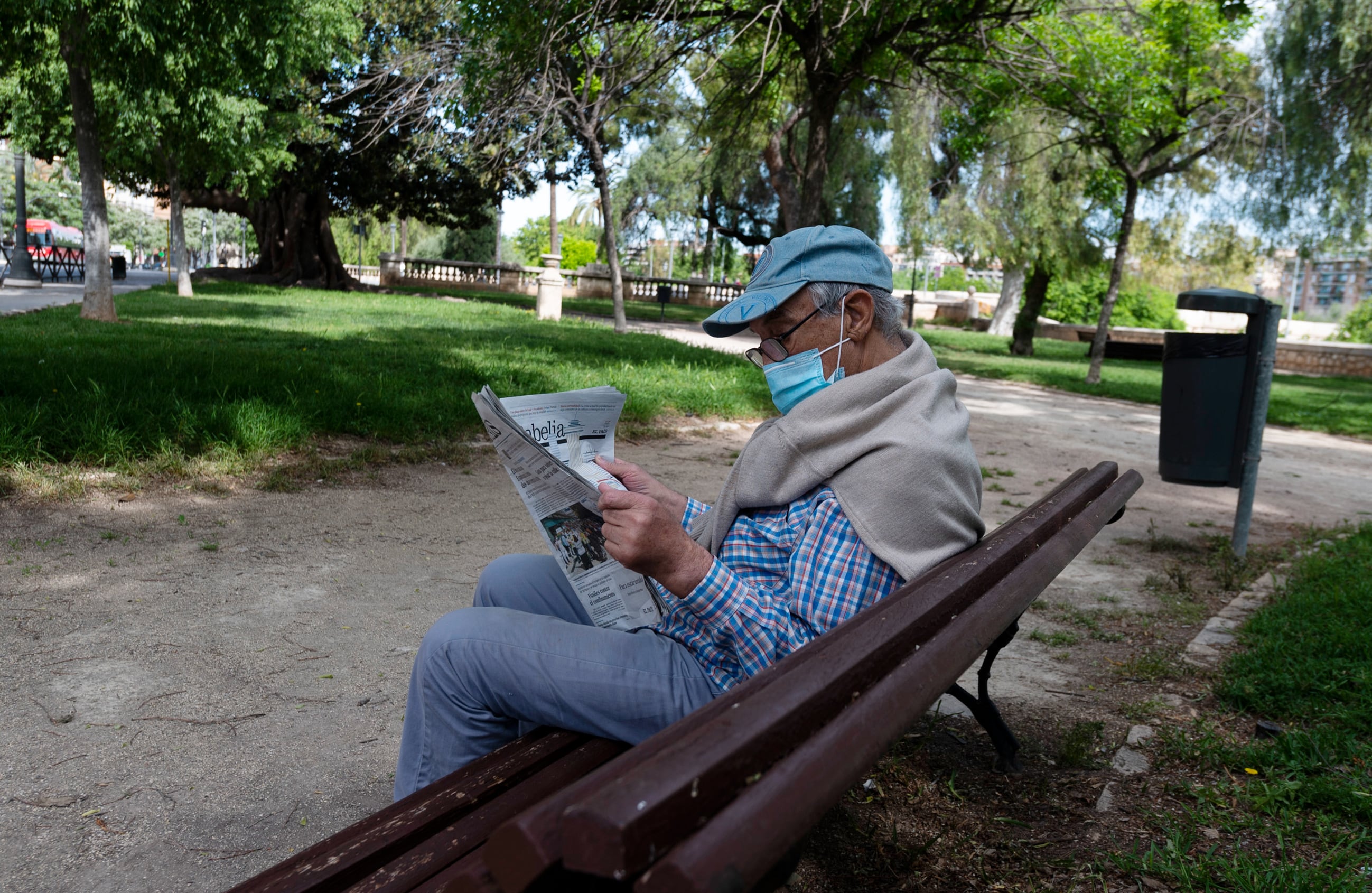 Un hombre lee el periódico en un parque de València