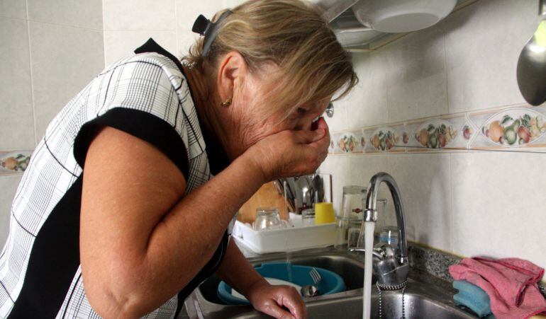 Una veïna de Monistrol de Montserrat mentre olora l'aigua que surt de l'aixeta de casa seva