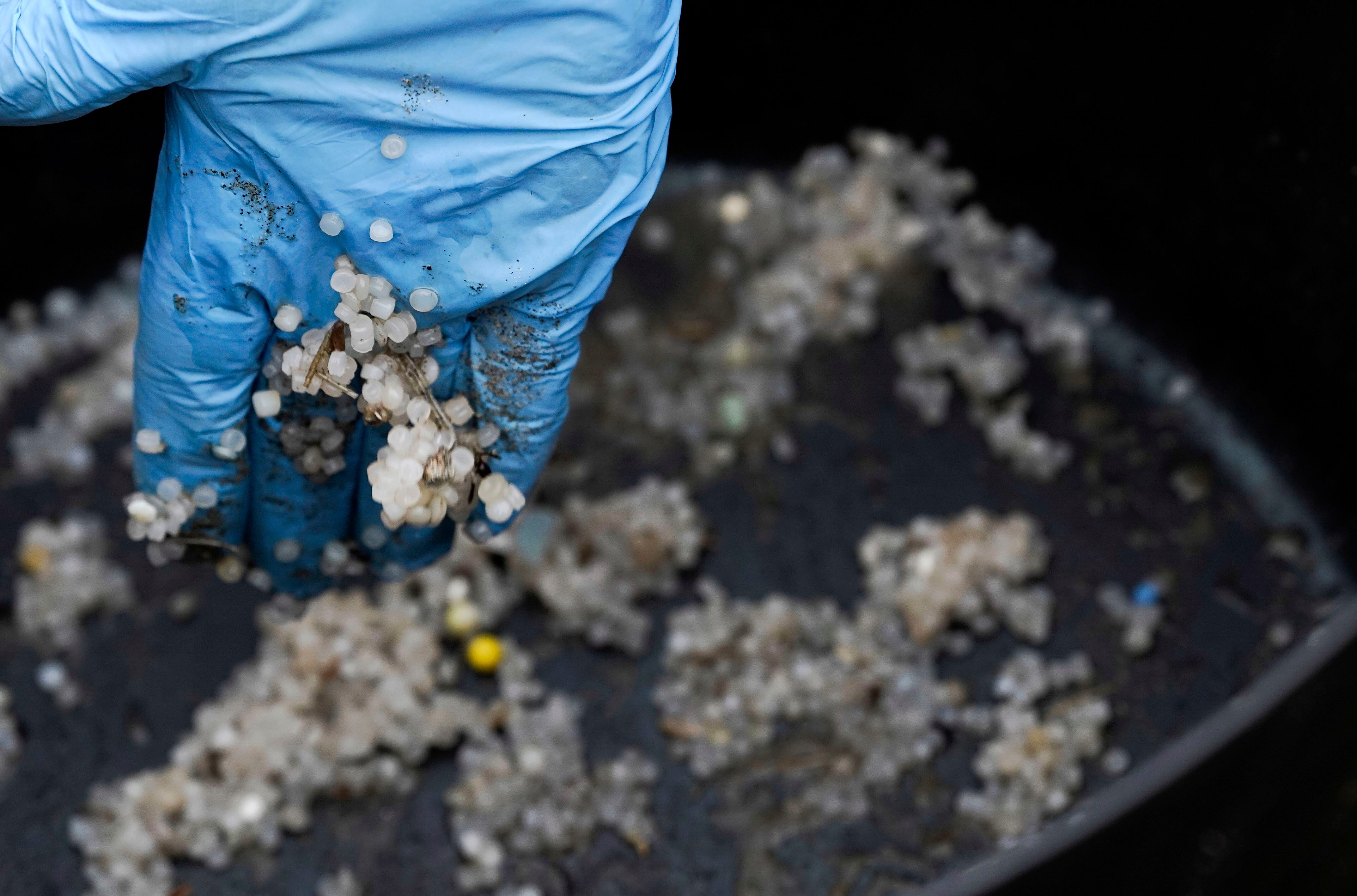 Operarios recogen pellets este miércoles en la playa asturiana de Salinas.