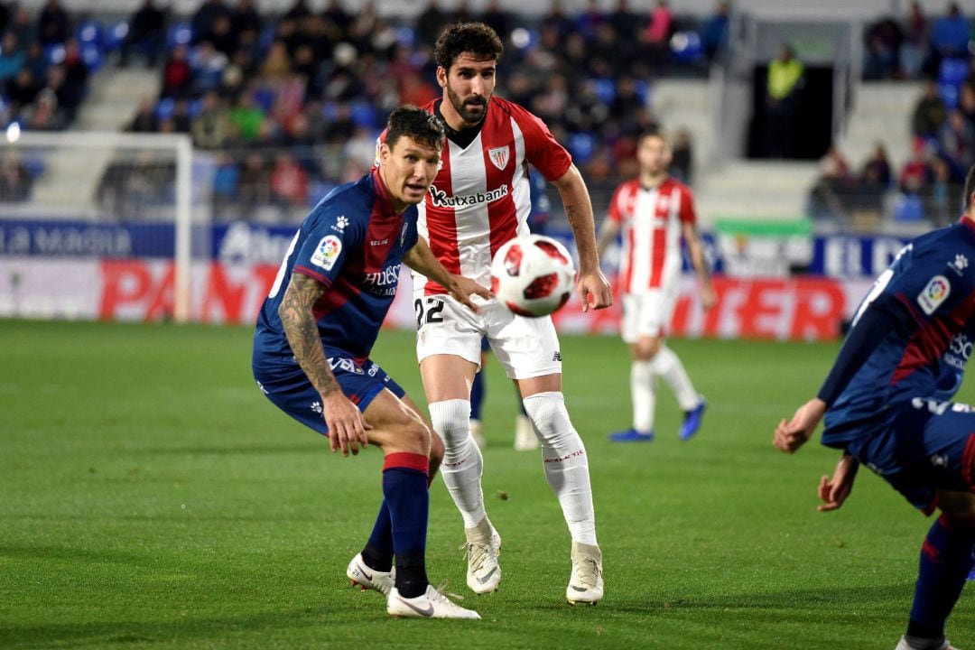 El centrocampista del Athletic Raúl García (d) y el centrocampita del Huesca Damián Musto (i) durante el partido de vuelta de los dieciseisavos de final de la Copa del Rey disputado hoy en el estadio de El Alcoraz