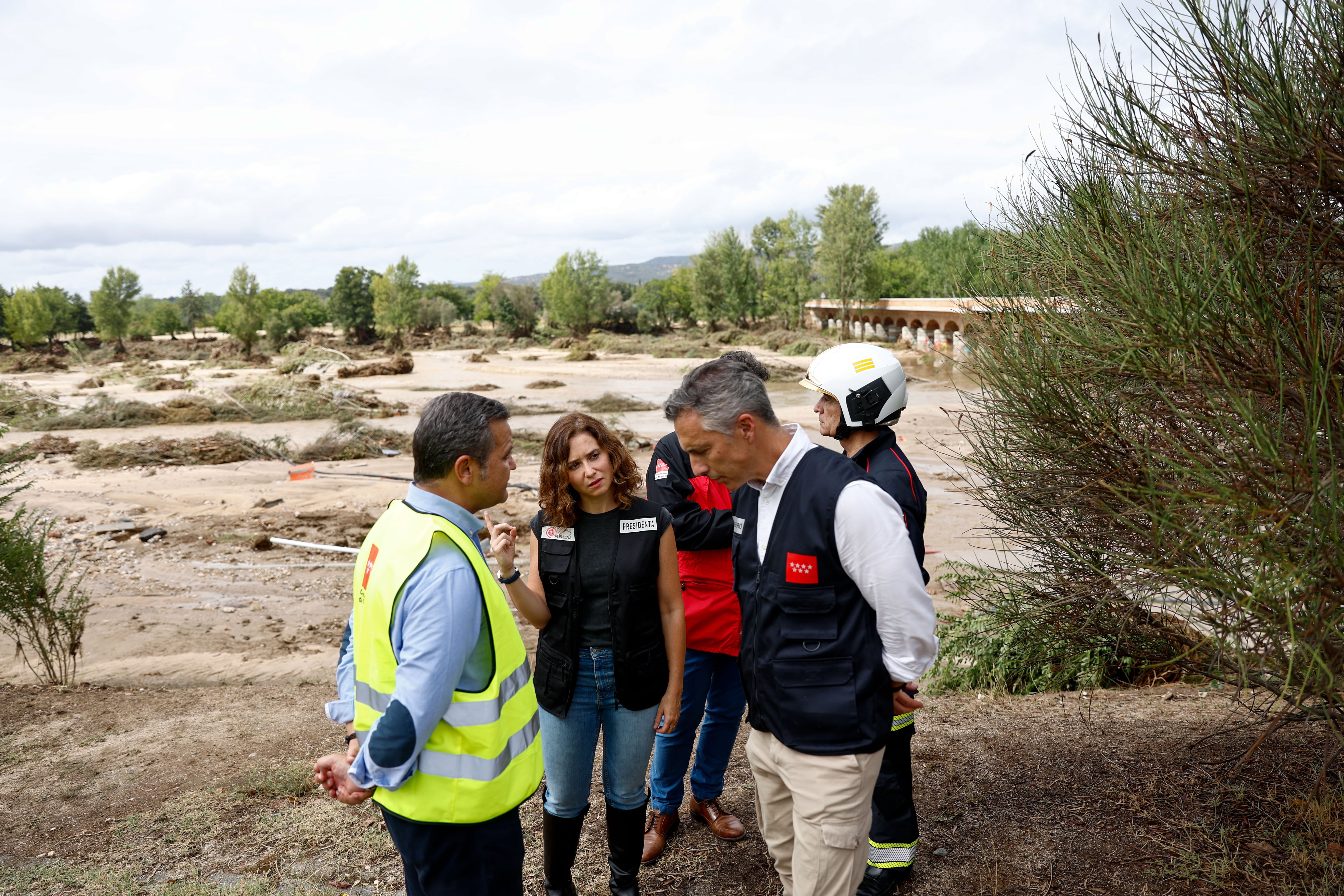 La presidenta de la Comunidad de Madrid, Isabel Díaz Ayuso (2i), acude este lunes al puesto de mando avanzado habilitado por la ASEM 112 en Aldea del Fresno, municipio afectado por las fuertes lluvias y tormentas de la DANA, este lunes. En Aldea del Fresno la crecida del cauce ha provocado roturas en dos puentes, en concreto son los accesos desde las carreteras M507 y M510. Los equipos de emergencias regionales están trabajando especialmente en la búsqueda de un desaparecido y del vehículo en el que viajaba por lo que los esfuerzos en esa zona se van a centrar en intentar localizarlos.